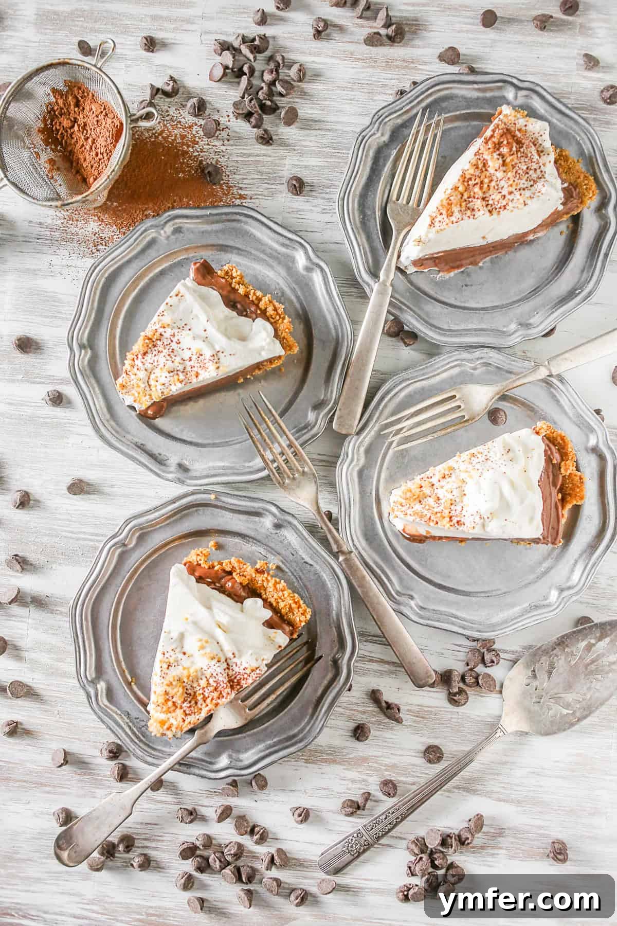 This super simple chocolate orange pudding pie is a breeze to make! Crazy delicious and packed into a pretzel crust. It's the prefect sweet and salty bite! Four slices of Chocolate Orange Pudding Pie on metal plates.
