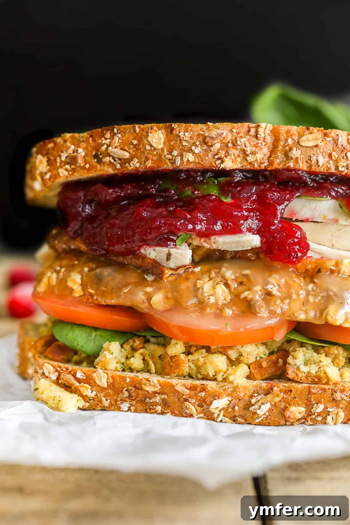 This leftover Thanksgiving sandwich with moist maker is the perfect way to pay homage to your favorite Friends episode. All the taste of a Thanksgiving dinner with a secret gravy soaked moist maker middle! A perfectly layered Leftover Thanksgiving Sandwich, showcasing its delicious components including turkey, stuffing, and cranberry sauce.