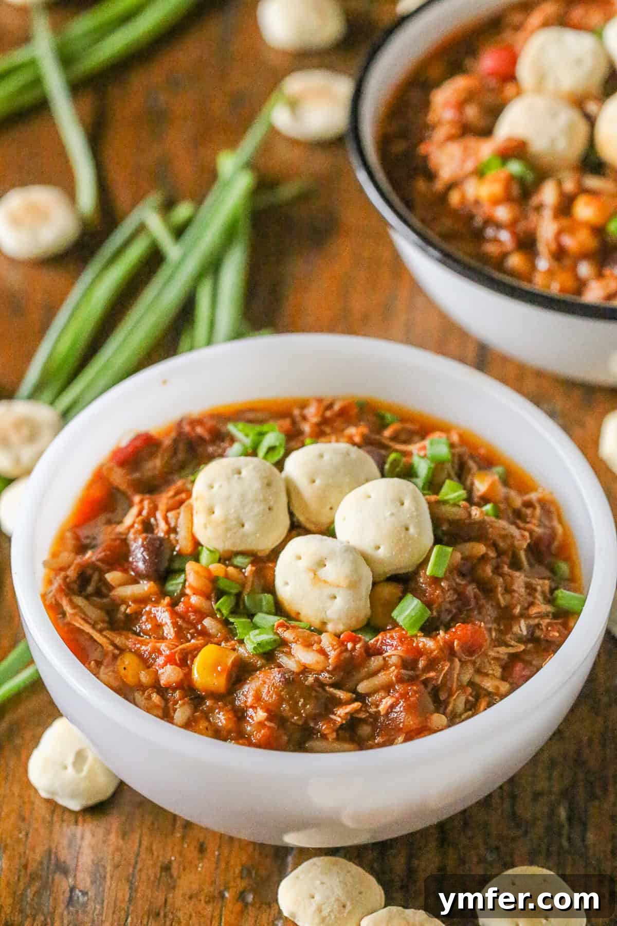 Hearty Wild Rice Turkey Chili: A flavorful and spicy way to reinvent Thanksgiving turkey, perfectly served with crunchy crackers. A bowl of vibrant Wild Rice Turkey Chili, garnished with fresh herbs and surrounded by golden crackers on a rustic wooden table.