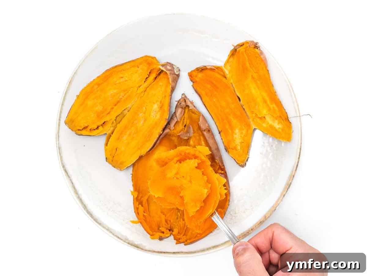 Golden Vegan Sweet Potato Delight 10 A perfectly microwaved sweet potato, cut in half and steaming, ready for its creamy flesh to be scooped out for the casserole