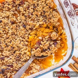 Golden Vegan Sweet Potato Delight 12 A serving of vegan sweet potato casserole with a silver spoon, showing the creamy texture and crunchy topping