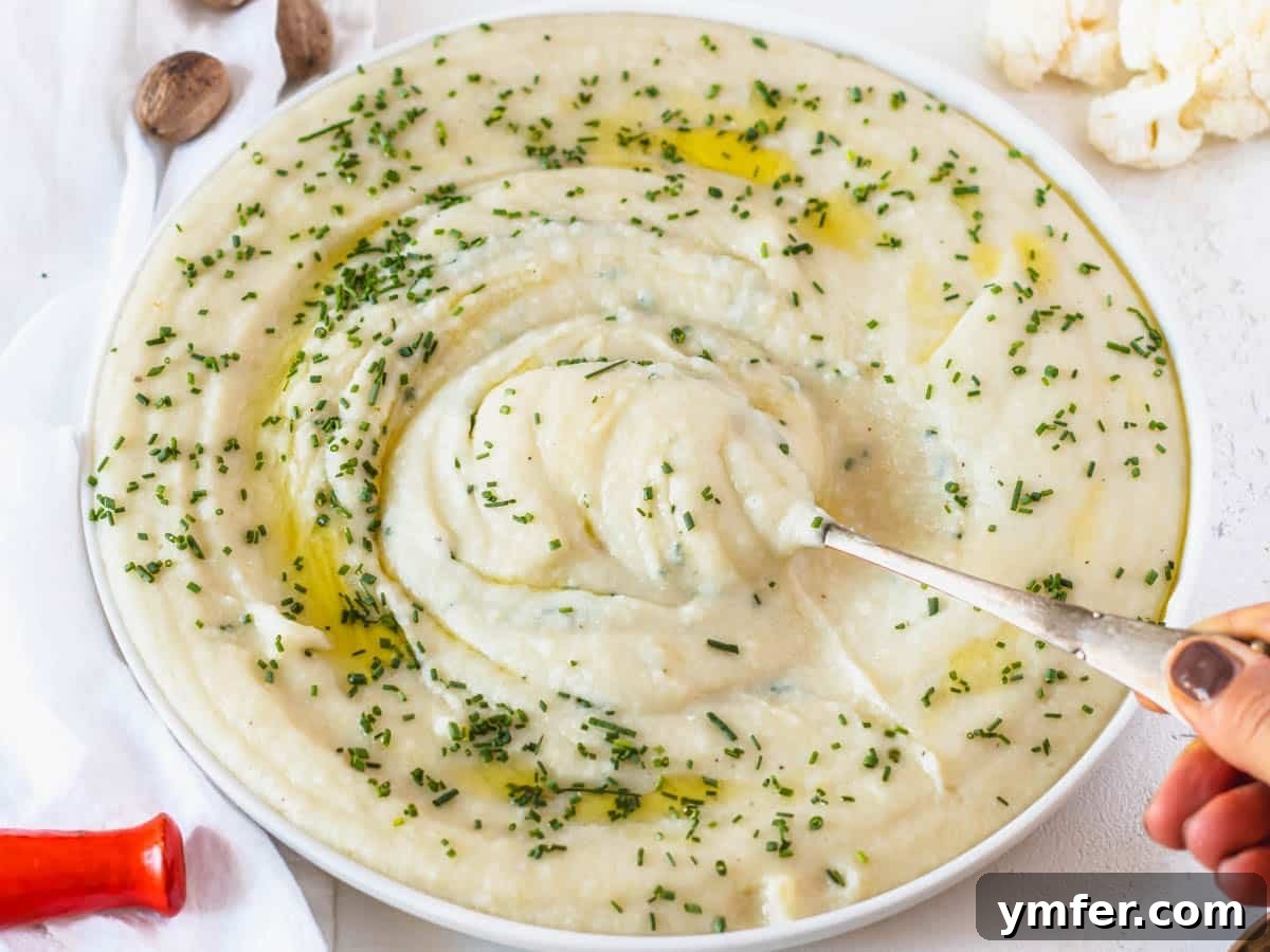 The Ultimate Vegetarian Thanksgiving Feast: 35 Recipes 13 Cauliflower potato mash with hand holding a spoon