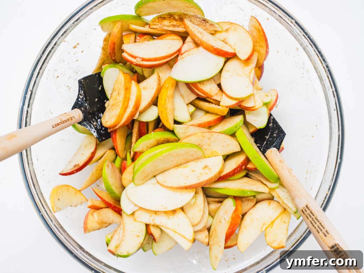 Plant-Based Apple Crumble 7 Apple slices mixed with brown sugar, cinnamon, and spices in a large bowl