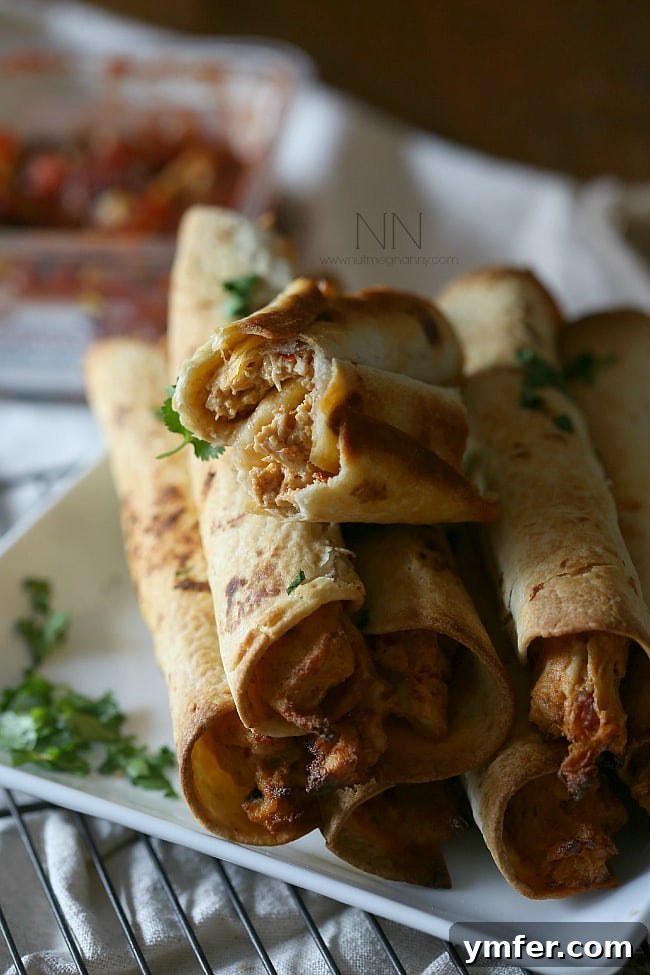 Inside a Creamy Chicken Taquito Creamy Chicken Taquitos cut in half to reveal the rich, cheesy chicken filling.