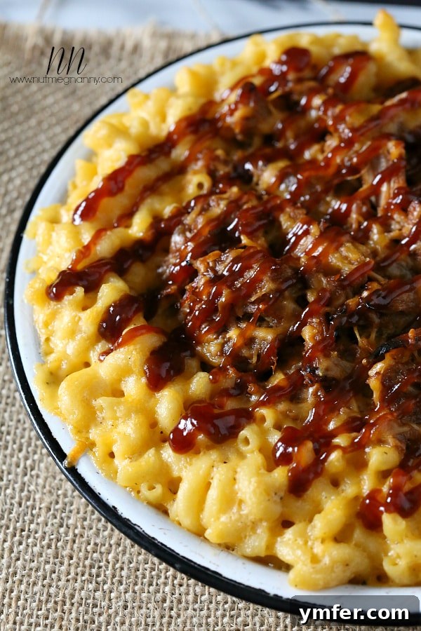 Pulled Pork Mac and Cheese: A Reader Favorite A close-up shot of rich, creamy Pulled Pork Mac and Cheese, featuring tender shredded pork nestled within golden macaroni pasta, generously coated in a decadent cheese sauce, garnished with fresh herbs.