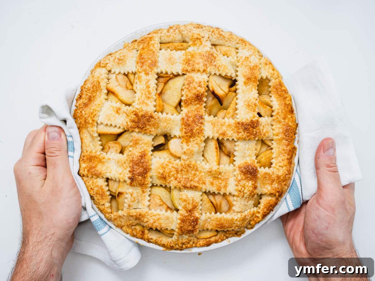 Plant-Based Apple Perfection 14 vegan apple pie after baking with hands and kitchen towel