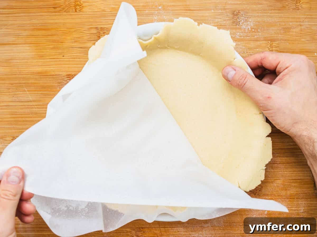 Plant-Based Apple Perfection 10 vegan pie crust in a white pie plate and hands