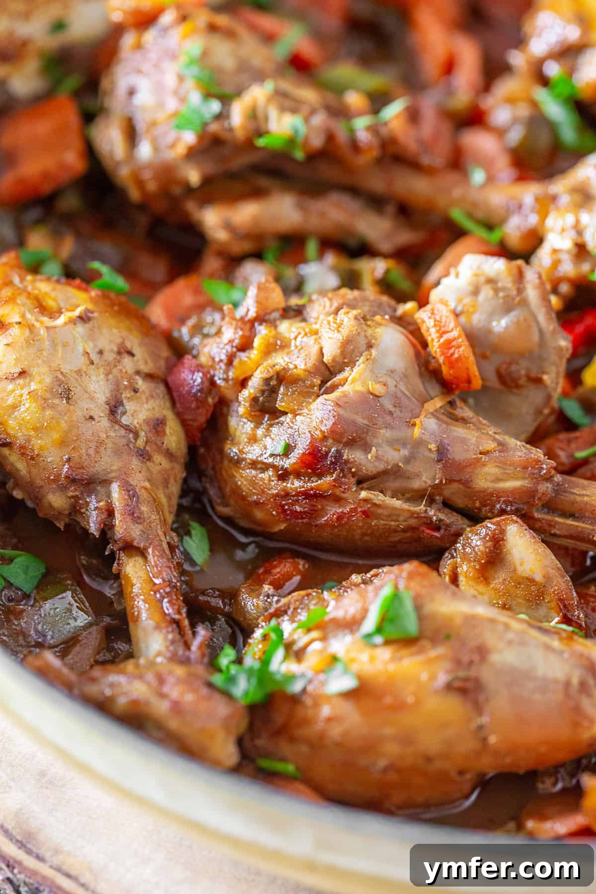 Traditional Grenadian chicken stew cooking in an iron pot, radiating warmth and aroma. Grenadian Chicken Stew simmering in a large pan on the stovetop.