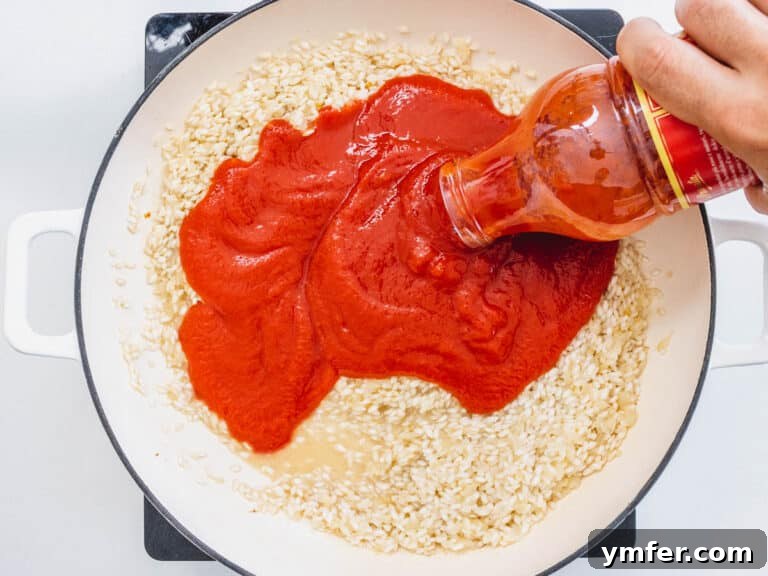 Tomato passata added to a white skillet