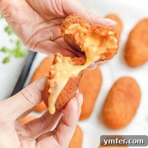 Roman Supplì 6 Homemade Italian supplì with melted cheese and female hands, showcasing the cheesy pull.