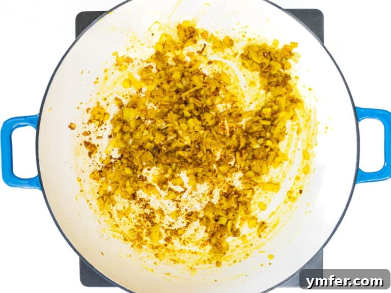 Golden Potato Delight 10 Flavor base with spices and onion in a skillet, gently cooking and releasing aromas.