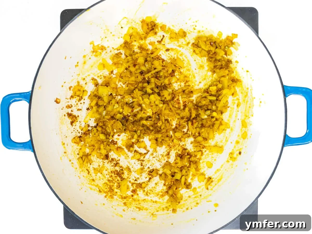 Golden Potato Delight 5 Aromatic flavor base with fragrant spices and softened onion gently cooking in a skillet, ready for the next step