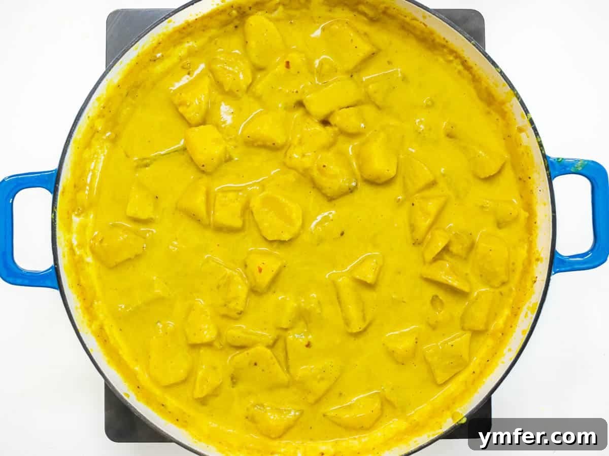 Golden Potato Delight 6 Tender potatoes simmering gently in a creamy coconut milk and rich spice base, absorbing all the flavors