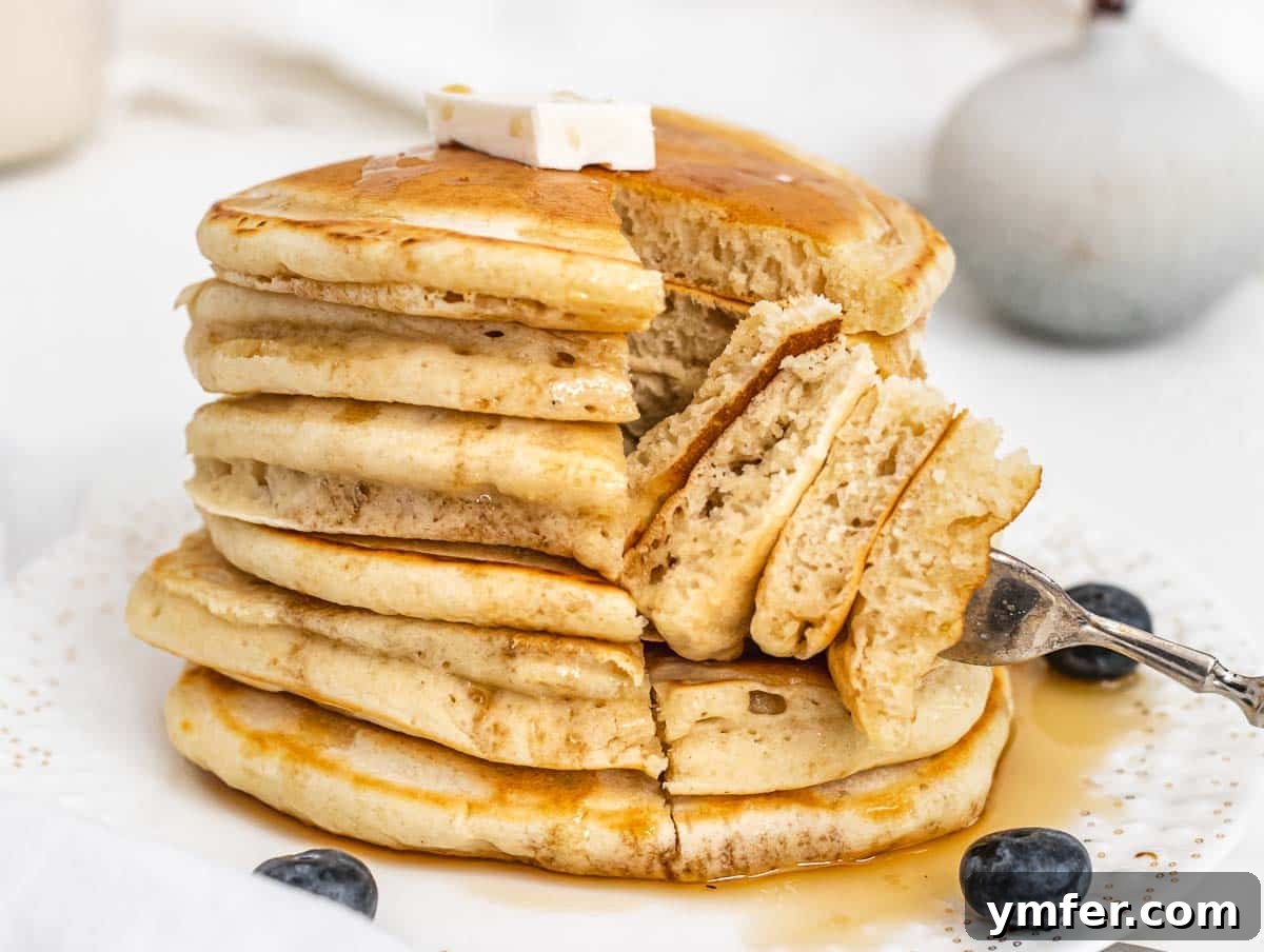 Egg-Free Delights 15 Stack of fluffy vegan pancakes with a slice cut open