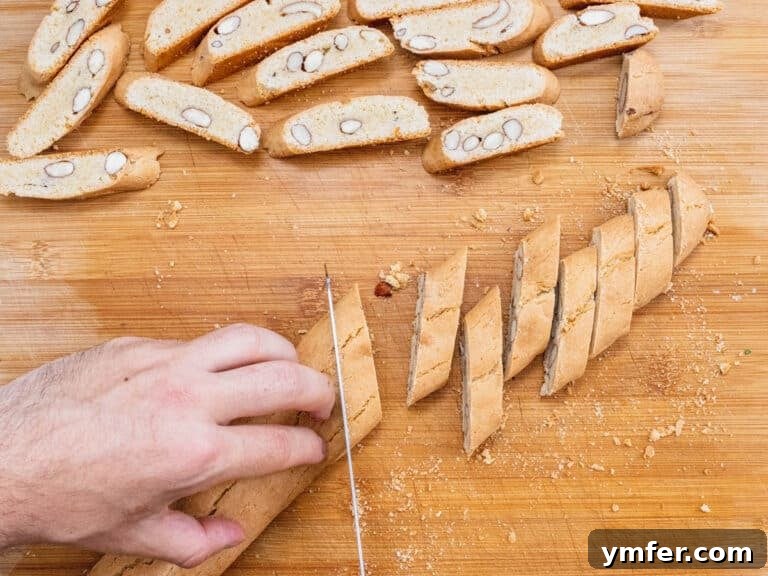 Hands cutting biscotti with a serrated knife
