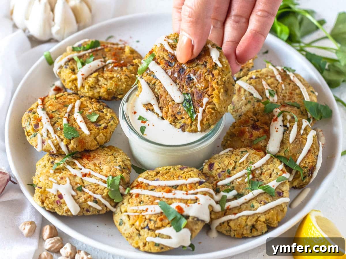 30 Plant-Based Protein Power Meals 23 Chickpea fritters with tahini sauce and fresh parsley and a hand dipping a fritter