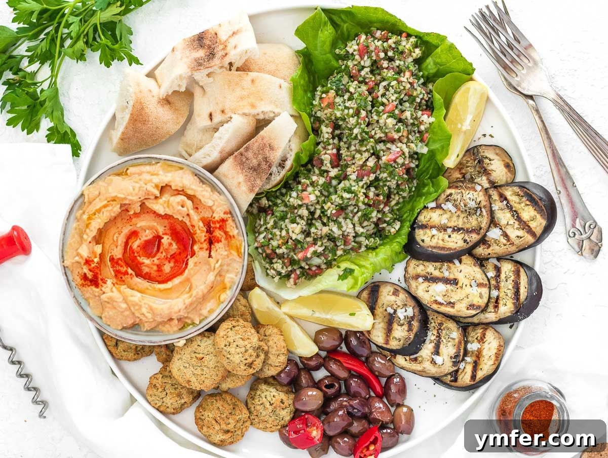 Velvety Roasted Red Pepper Hummus 12 A colorful Mediterranean mezze platter featuring roasted red pepper hummus, fresh vegetables, and pita bread.