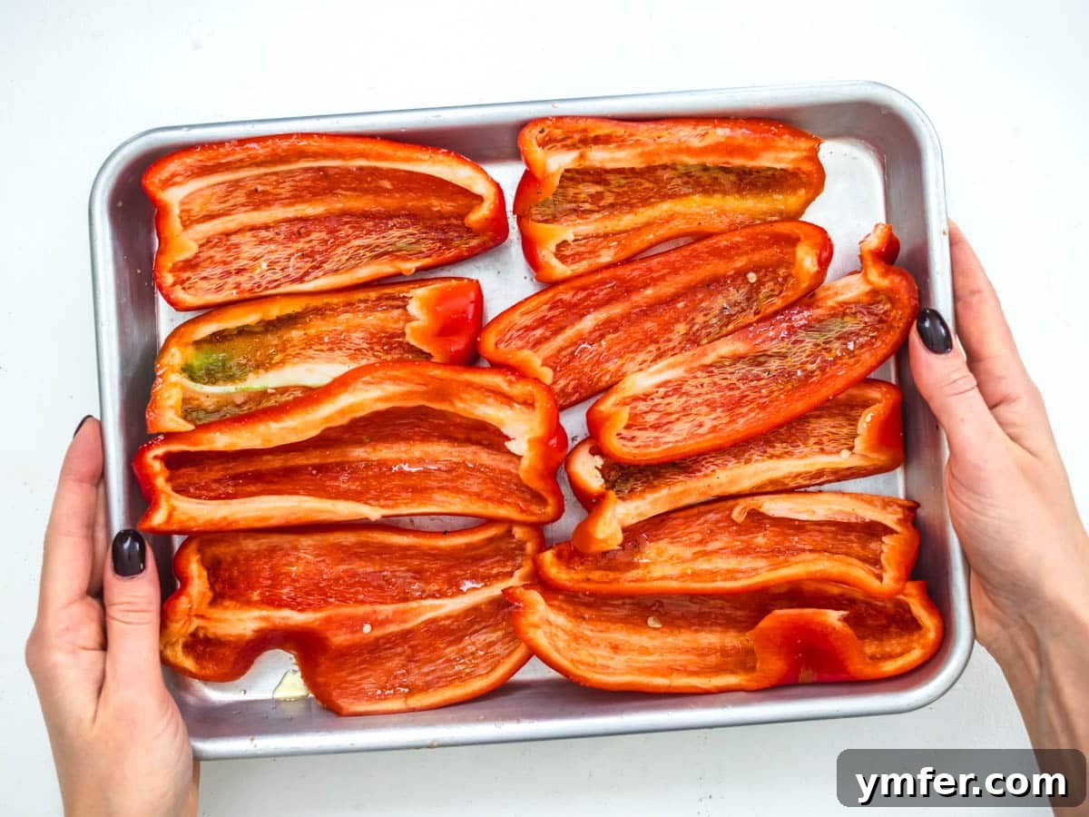 Velvety Roasted Red Pepper Hummus 6 Fresh red bell pepper chunks ready for roasting on a baking sheet.