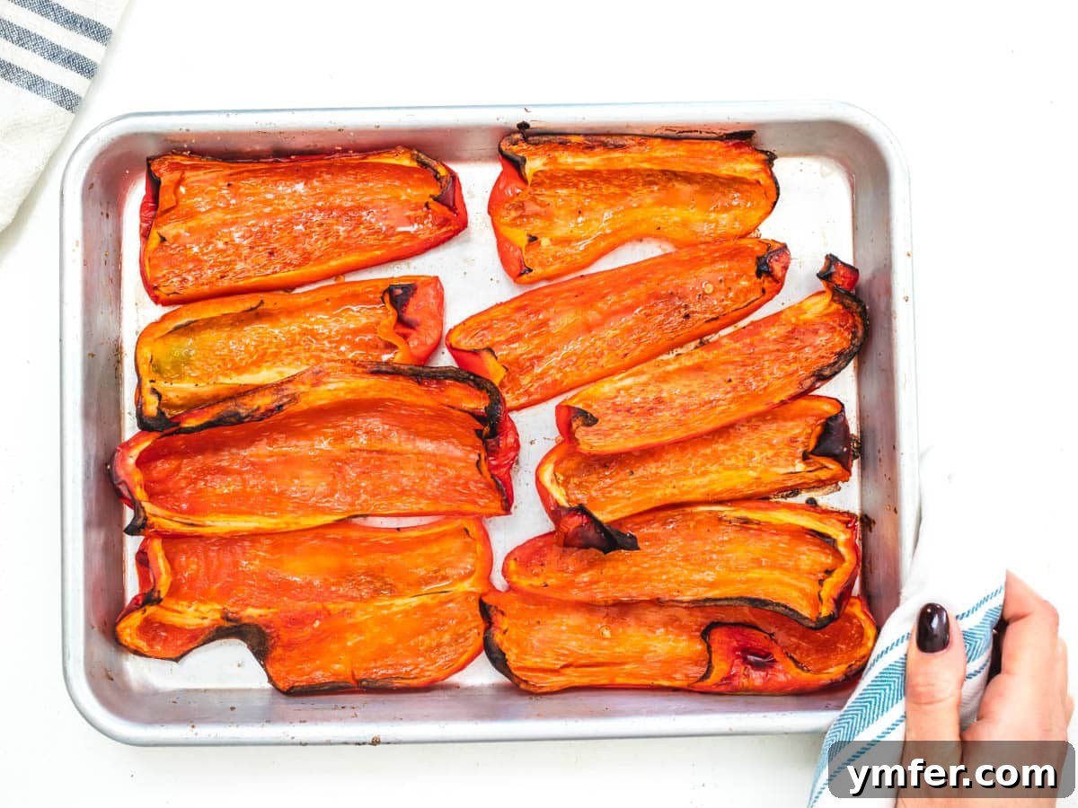 Velvety Roasted Red Pepper Hummus 7 Roasted red bell peppers on a baking tray, softened and slightly charred.