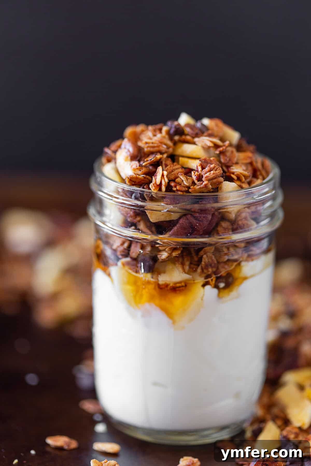 Spiced Banana Bread Granola 2 Banana Bread Granola served overtop yogurt with maple syrup, showcasing its delicious texture and appeal.