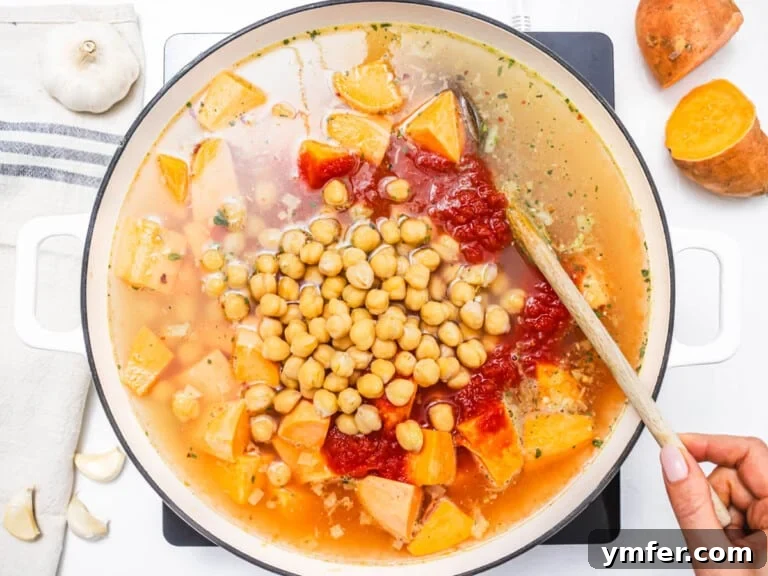 Soulful African Peanut Stew 14 chickpeas, sweet potato and vegetable broth in a skillet with a wooden spoon
