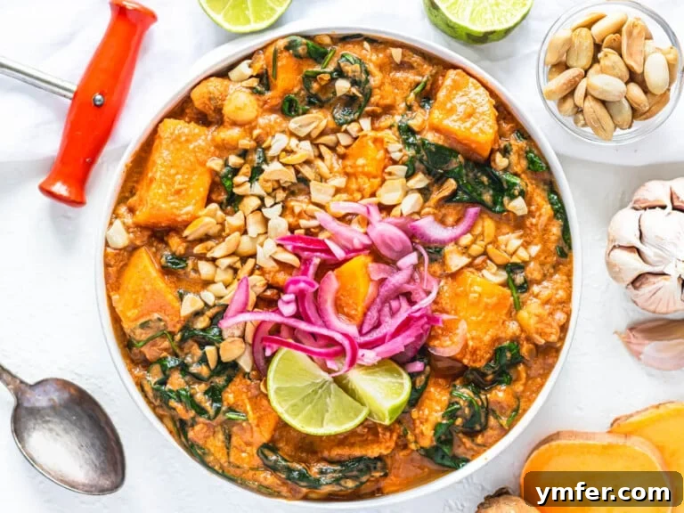 Soulful African Peanut Stew 17 African peanut stew with pickled red onions in a white bowl and peanut garnish