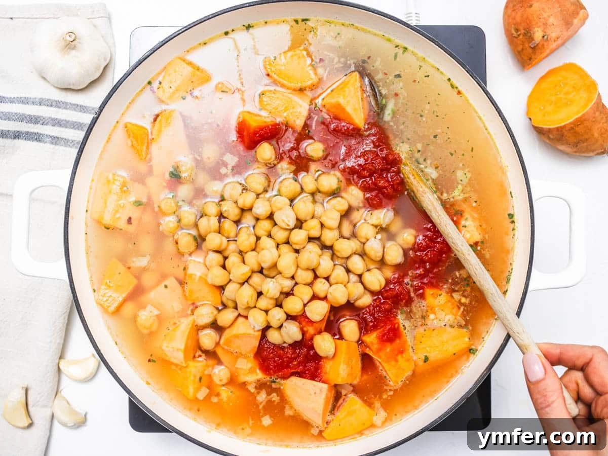 Soulful African Peanut Stew 8 chickpeas, sweet potato and vegetable broth in a skillet with a wooden spoon
