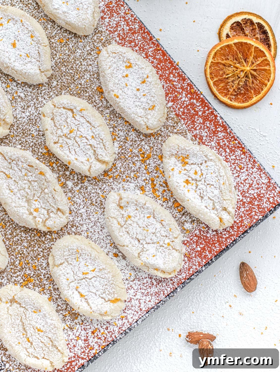 Zesty Orange Almond Delights 2 Beautifully dusted Vegan Orange Almond Cookies on a plate, ready to be served.