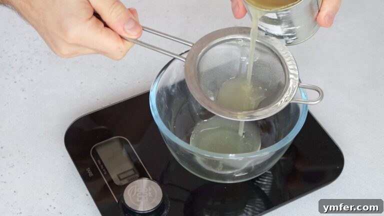 Zesty Orange Almond Delights 7 Measuring aquafaba, the chickpea liquid, into a bowl.