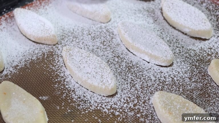 Zesty Orange Almond Delights 13 Shaped vegan orange almond cookies resting on a plate before chilling.