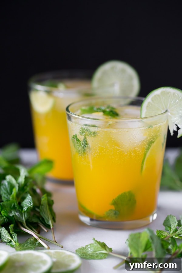Mango Bliss Mojito 4 A beautifully prepared mango mojito in a short cocktail glass, expertly garnished with fresh lime and a sprig of mint, ready to be enjoyed.
