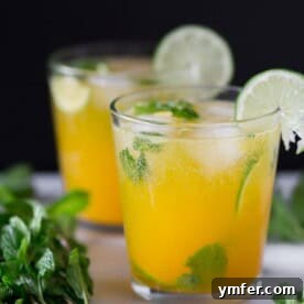 mango mojito in a short cocktail glass garnished with fresh lime and mint