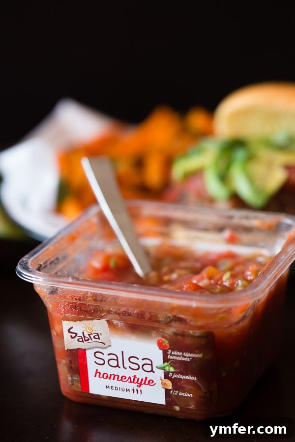 A close-up of a cheesy salsa burger, highlighting the fresh ingredients and vibrant colors, ready for a Cinco de Mayo celebration.