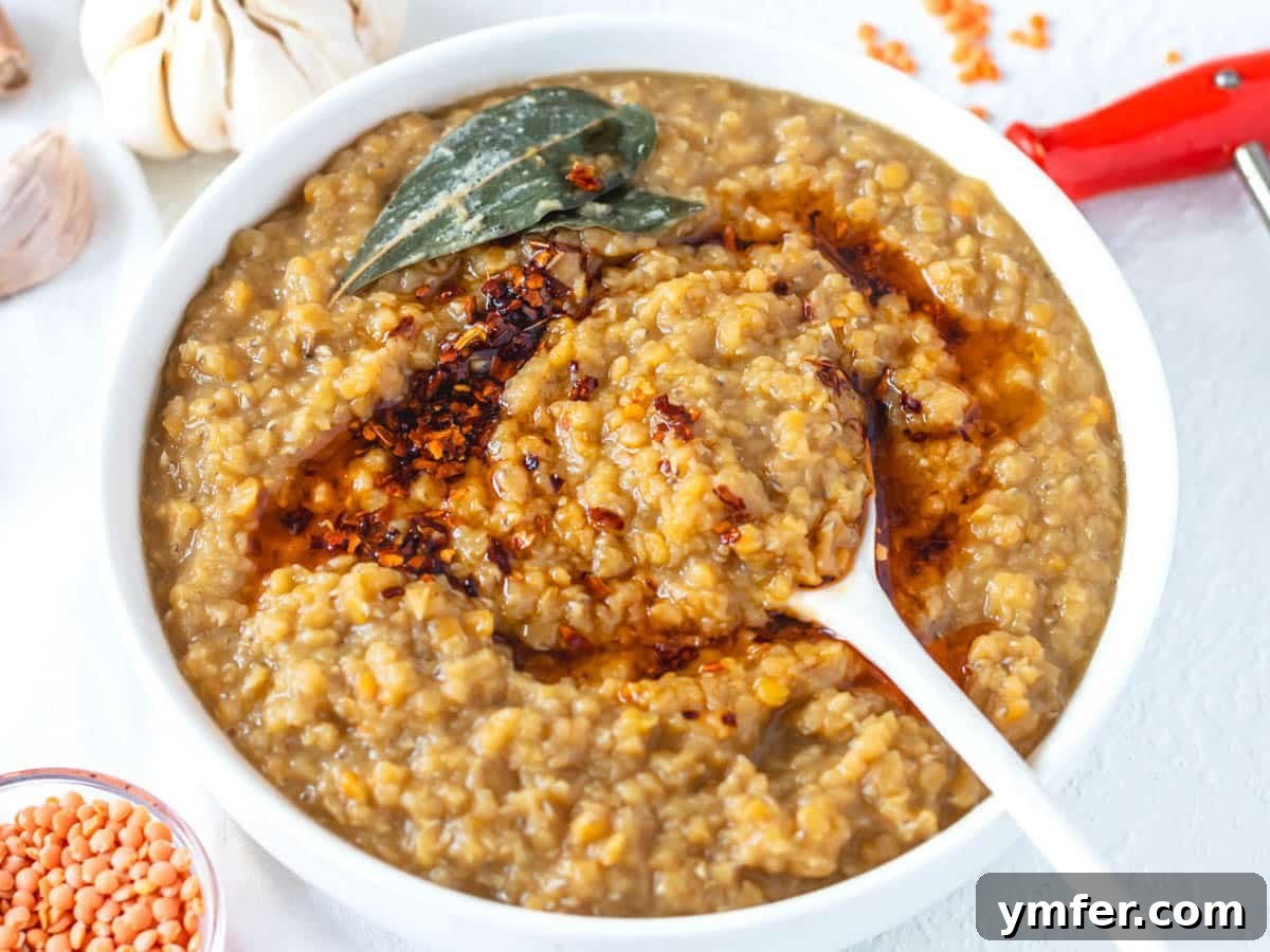 Perfect Red Lentils Every Time 7 Cooked red lentils in a white bowl with a white spoon, ready for serving