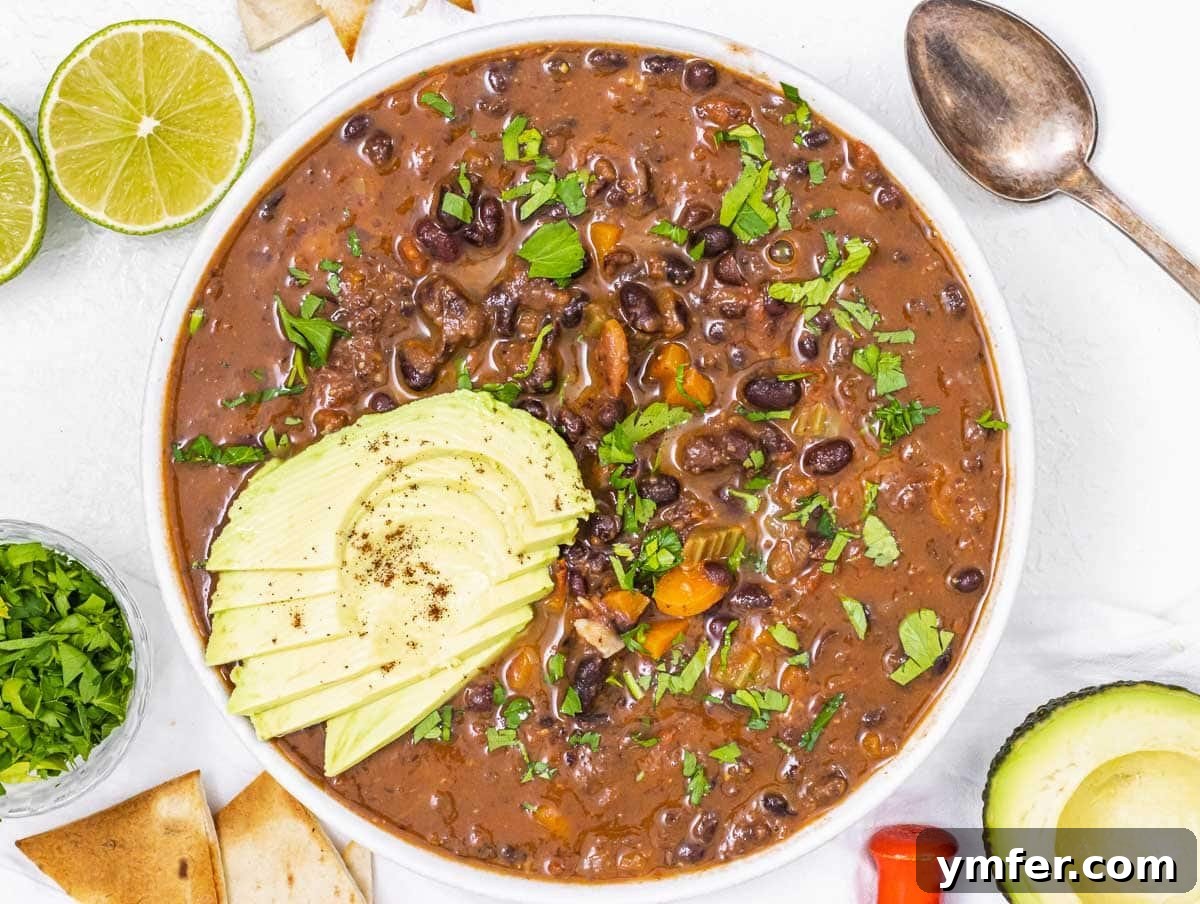 Plant-Powered Mondays 11 A bowl of rich black bean soup generously topped with fresh avocado slices