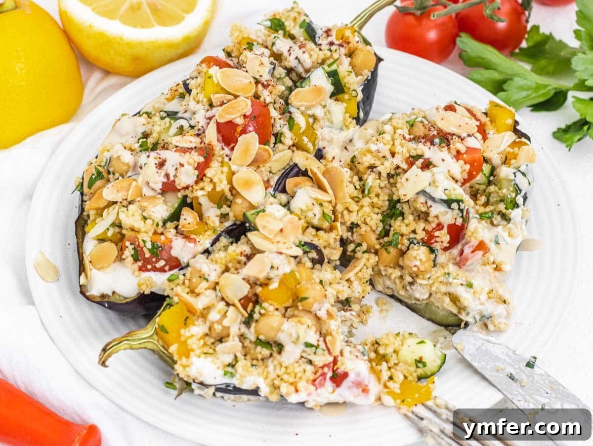 Plant-Powered Mondays 17 Fluffy couscous salad served on a tender roasted eggplant half with a fork and knife