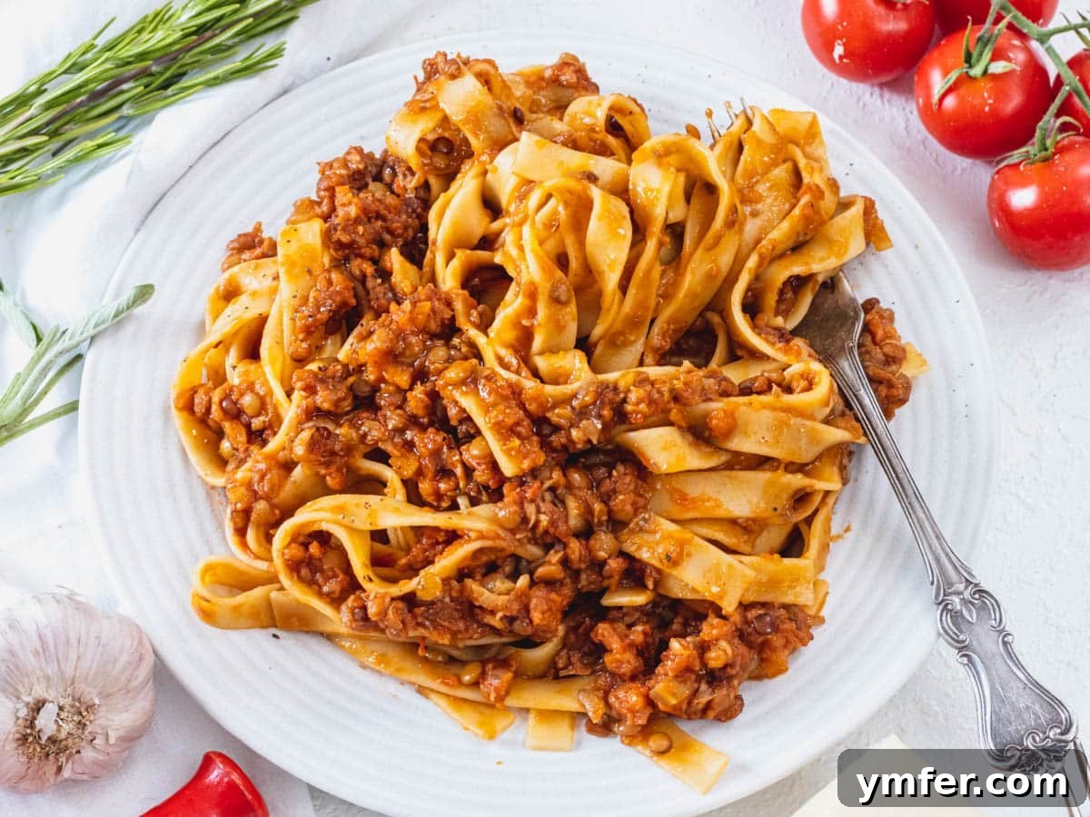 Plant-Powered Mondays 29 A plate of rich lentil bolognese served with pasta and a fork