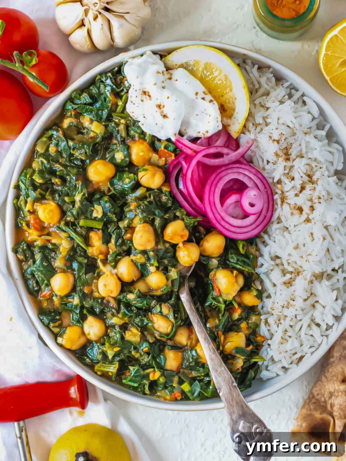 Spiced Chickpea and Spinach Curry 2 A vibrant bowl of Chana Saag, an Indian chickpea and spinach curry, garnished with fresh cilantro and a dollop of yogurt.