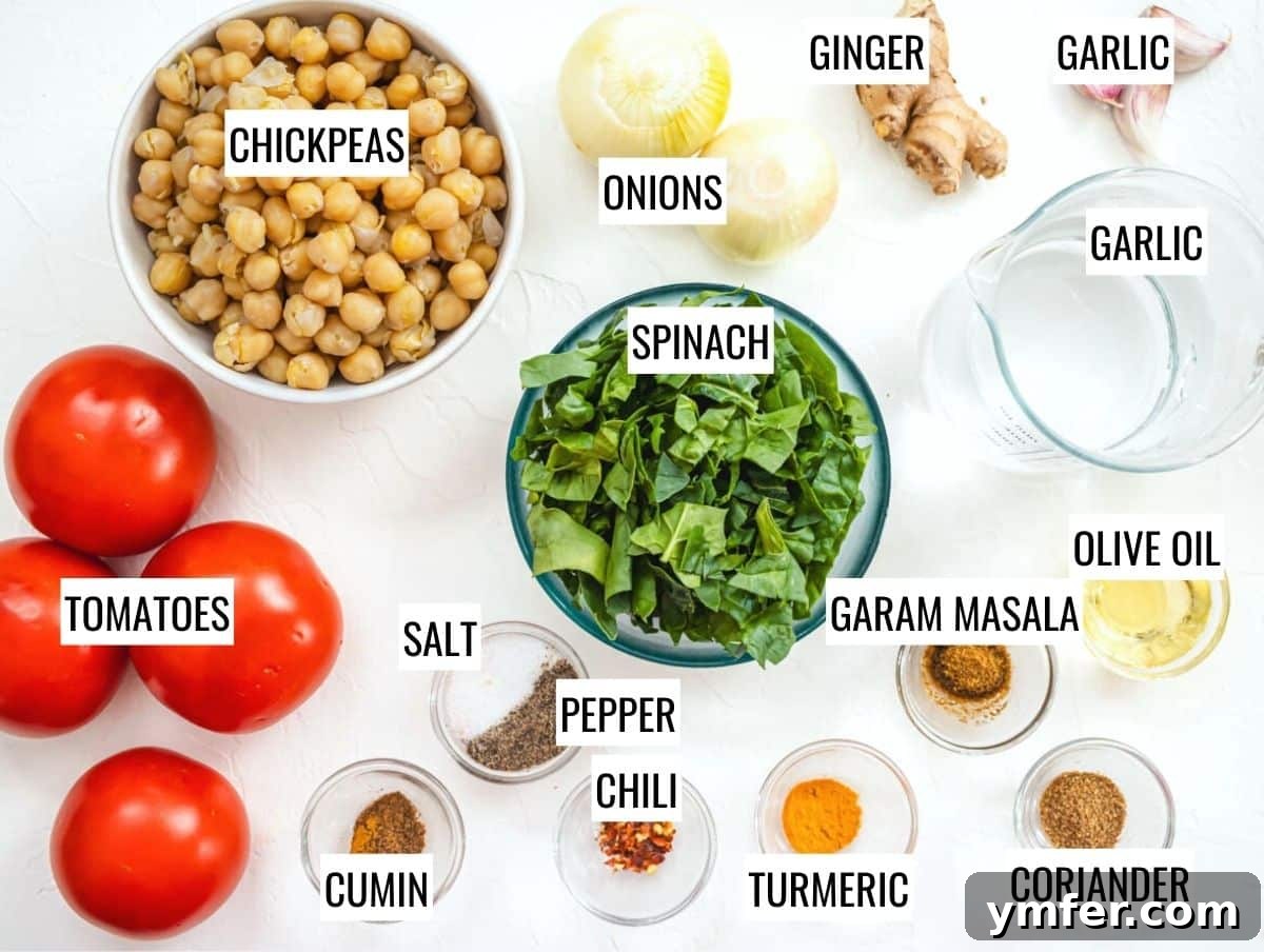 Spiced Chickpea and Spinach Curry 3 Fresh ingredients laid out for Chana Saag preparation, including spinach, chickpeas, tomatoes, onions, ginger, and garlic.