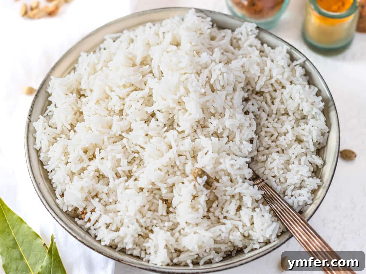 Mastering Fluffy Basmati Rice 7 A dark bowl of steaming, perfectly cooked basmati rice, prepared using the reliable immersion method, highlighting its individual, fluffy grains.