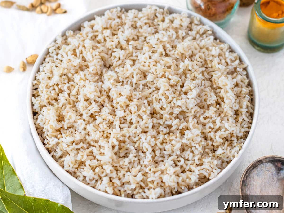 Mastering Fluffy Basmati Rice 8 A white bowl filled with cooked brown basmati rice, showcasing its hearty texture and distinct whole grain appearance.