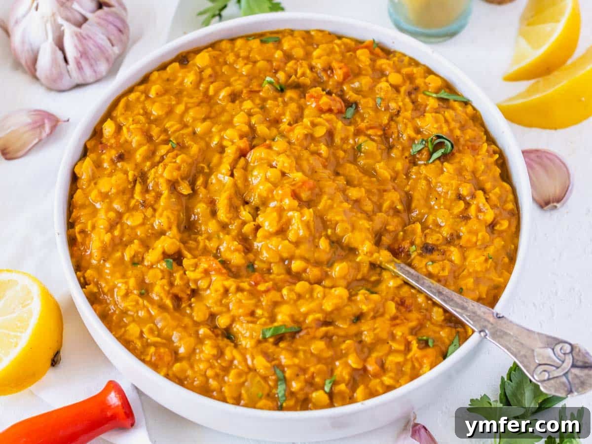 Golden Turmeric Creations 12 Lentil curry in a bowl with lemon and garlic around it
