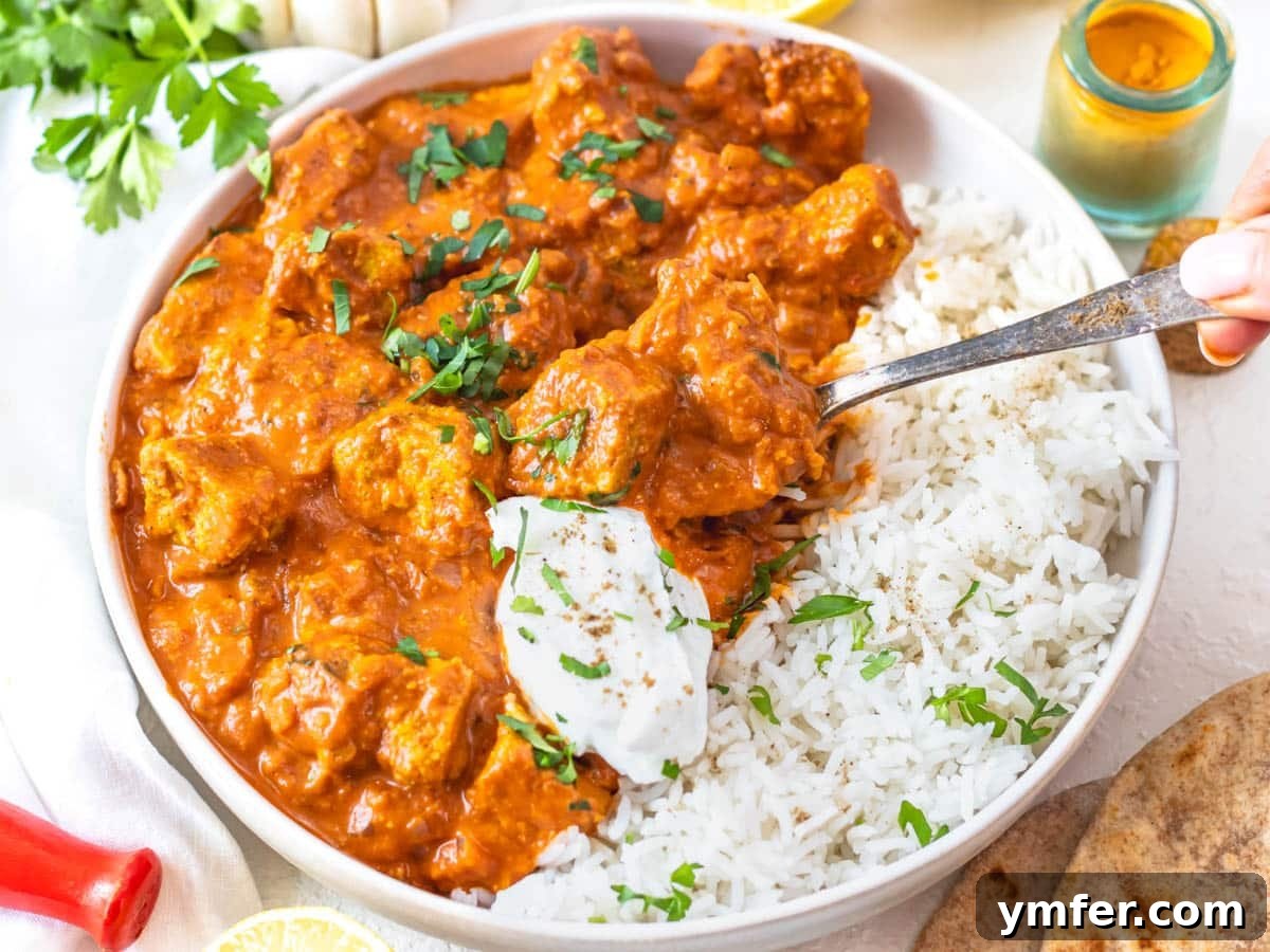 Golden Turmeric Creations 17 tofu tikka masala with a dollop of yogurt and a silver spoon
