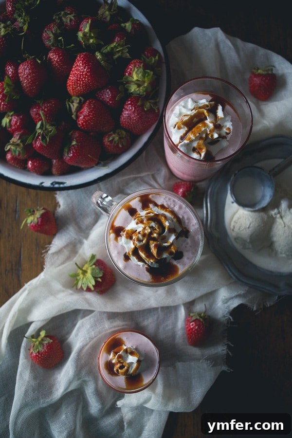 Velvet Strawberry Fraiche Shake 4 Overhead shot of a vibrant Strawberry Crème Fraîche Milkshake in a tall glass, garnished with whipped cream and a rich balsamic reduction swirl.