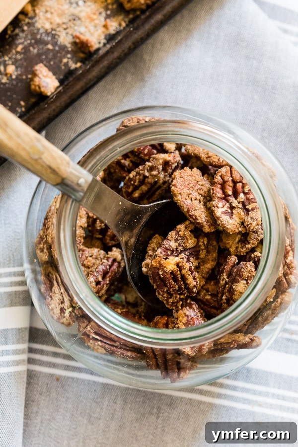 Caramelized Pecan Crunch 5 Praline Pecans in a jar, with a small spoon ready to scoop.