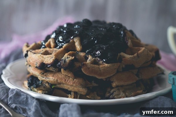 Berry Zucchini Oat Delight Waffles 3 A second shot of blueberry zucchini oat waffles, showcasing their golden-brown texture and fresh fruit topping.