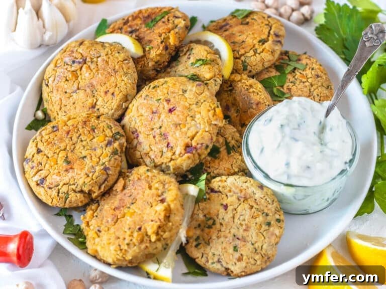 Chickpea fritters in a plate served with tzatziki sauce.