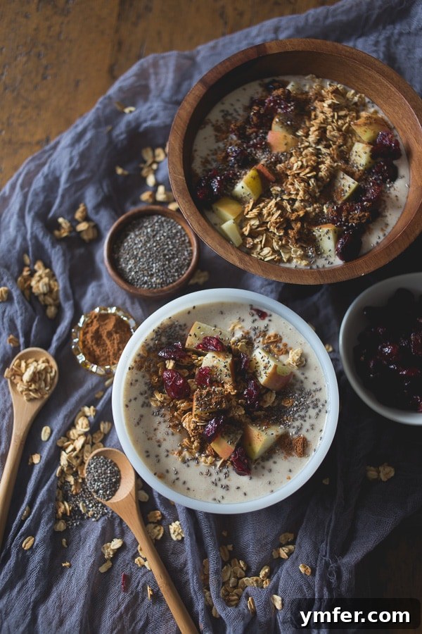 Spiced Apple Pie Smoothie Bowl 2 Two vibrant Apple Pie Smoothie Bowls, one in front, showcasing fresh apple slices, granola, and a dash of cinnamon, ready for a healthy breakfast.