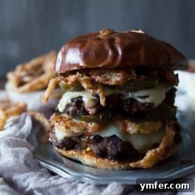 This chorizo beef burger with crispy onion straws is the perfect big mouth burger. Topped with bbq fry sauce, candied jalapeños and American cheese.