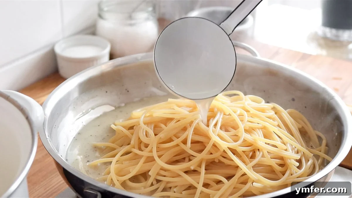 Creamy Vegan Pepper Pasta 11 Undercooked spaghetti being added to the pan with the creamy vegan cheese sauce.